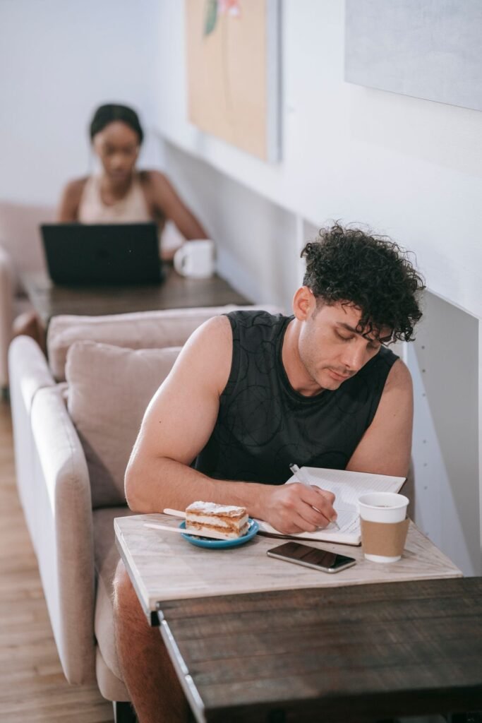 Person journaling with prompts at a coffee shop