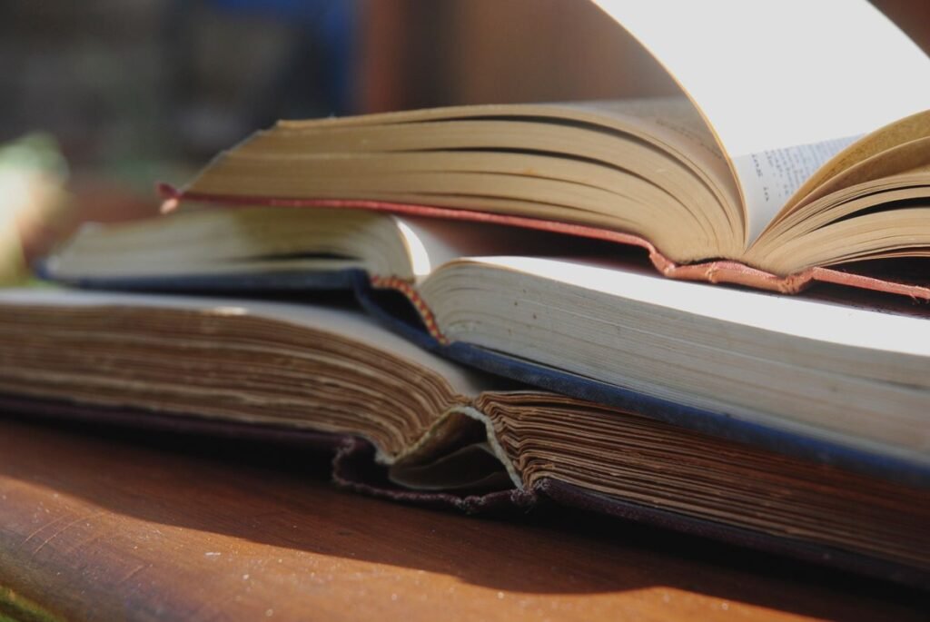 Stack of open books on a wooden table