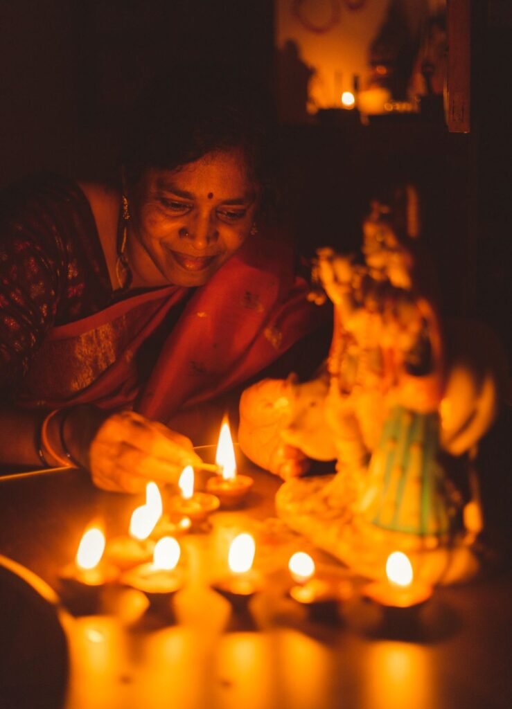 Woman lighting diya oil lamps for Diwali