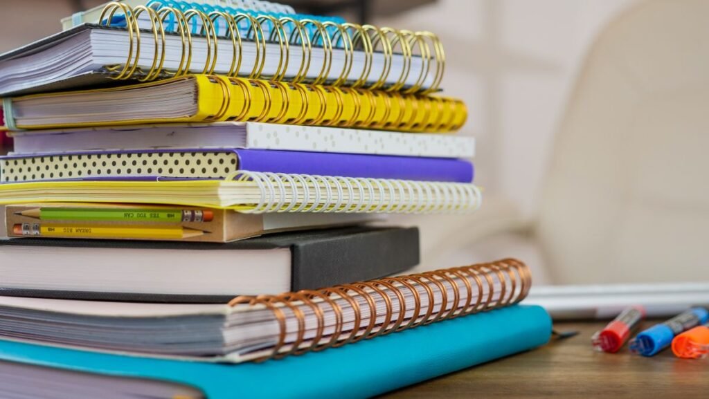 Stack of colorful notebooks and diaries on a desk