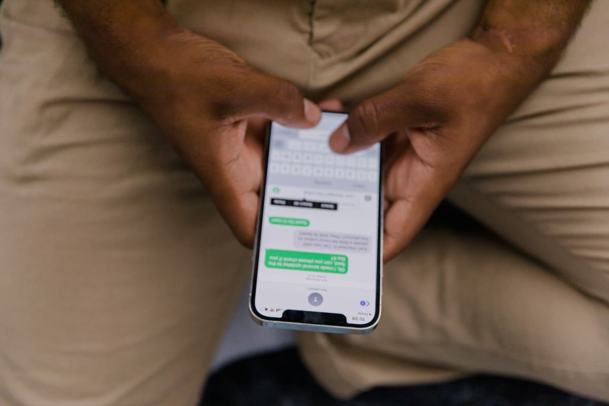 Close-up view of a man texting on his phone, representing instant messaging features