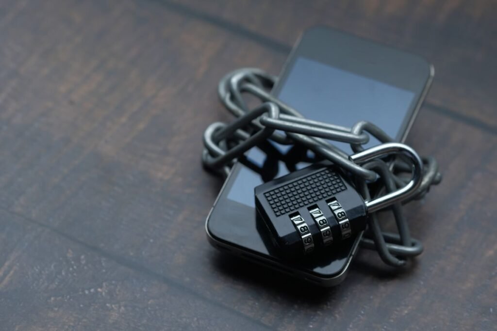 Smartphone secured with a padlock chain, representing defense cybersecurity for CMMC