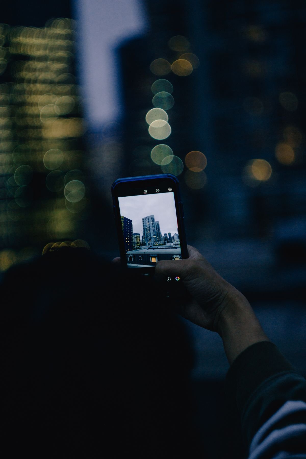 Hand holding a smartphone capturing content, representing saving photos and videos