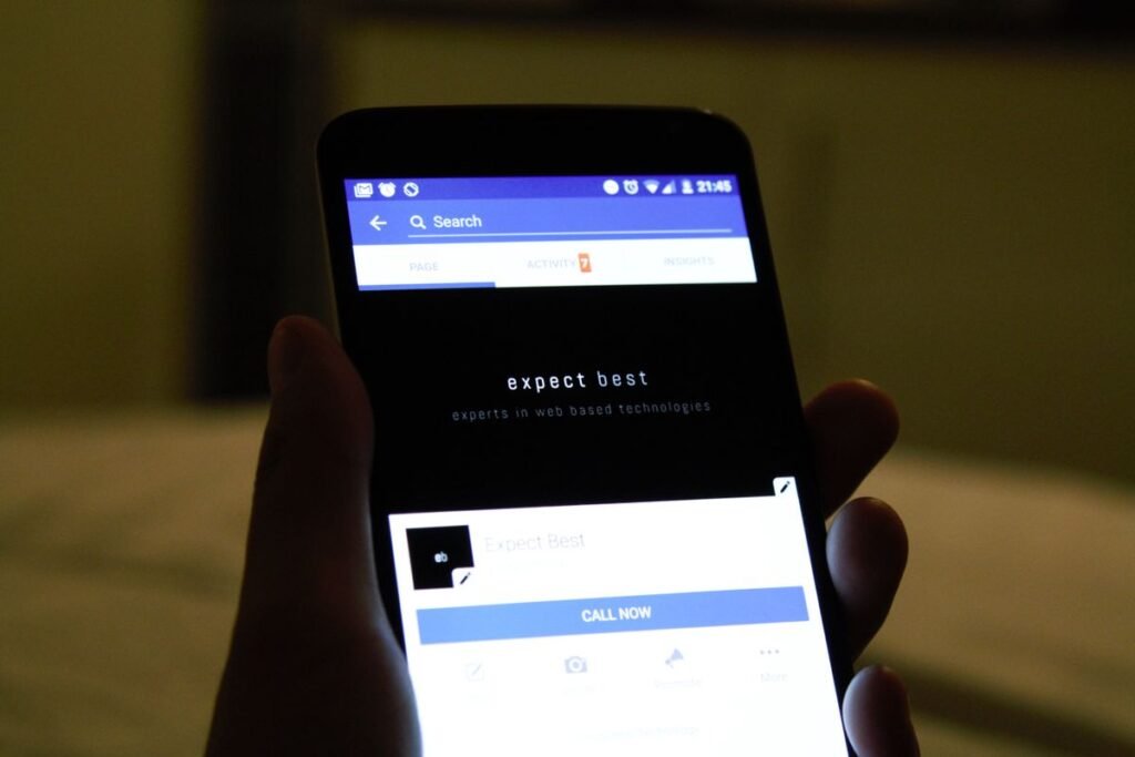 Close-up of a hand holding a smartphone, representing saving content from social media