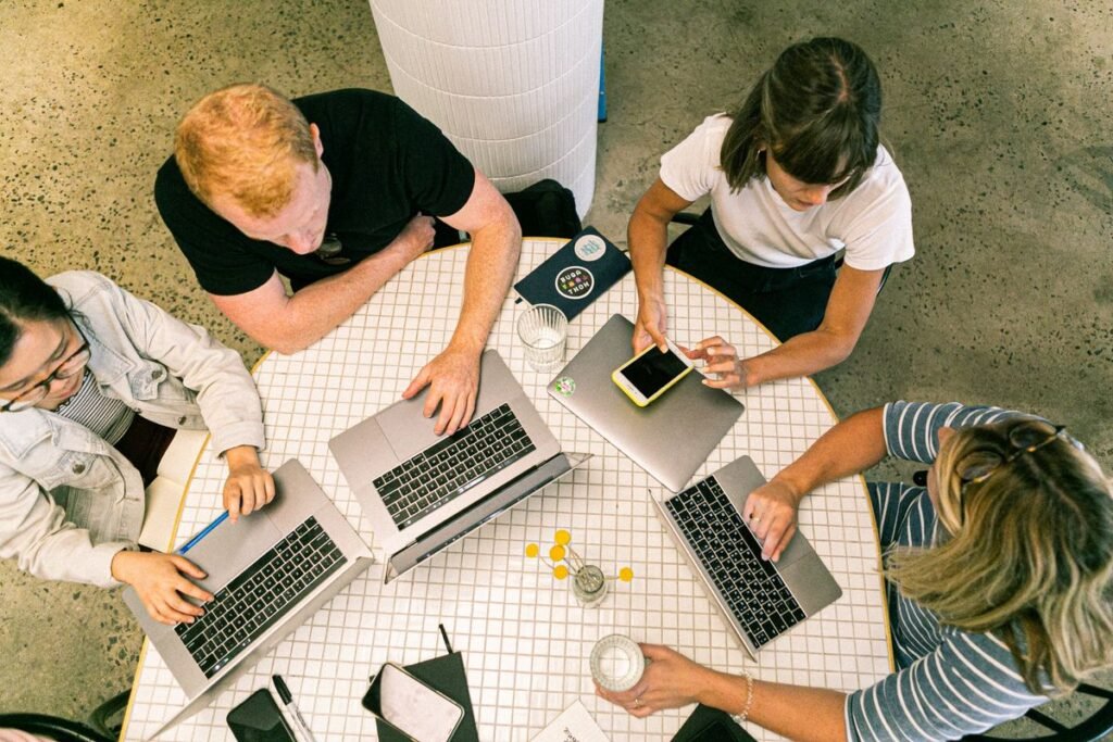 Team of professionals collaborating on laptops representing a cybersecurity team