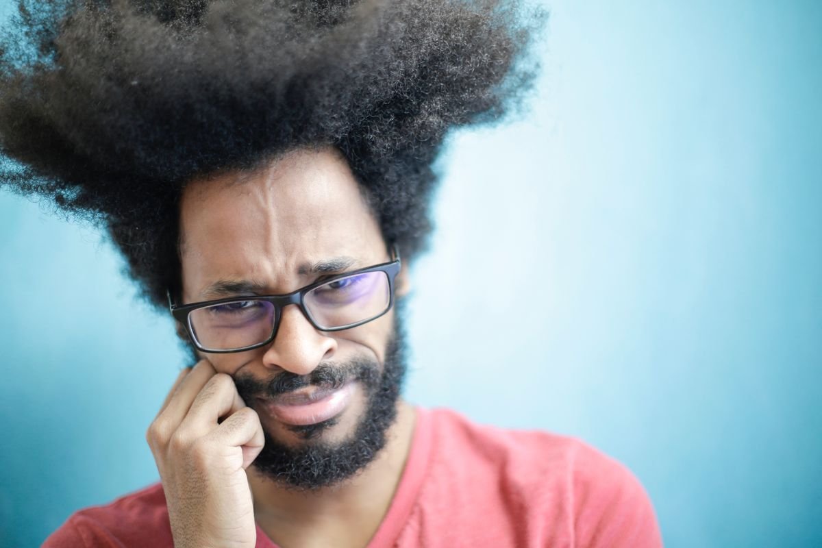 Frustrated person against a plain background, representing social isolation and being blocked online