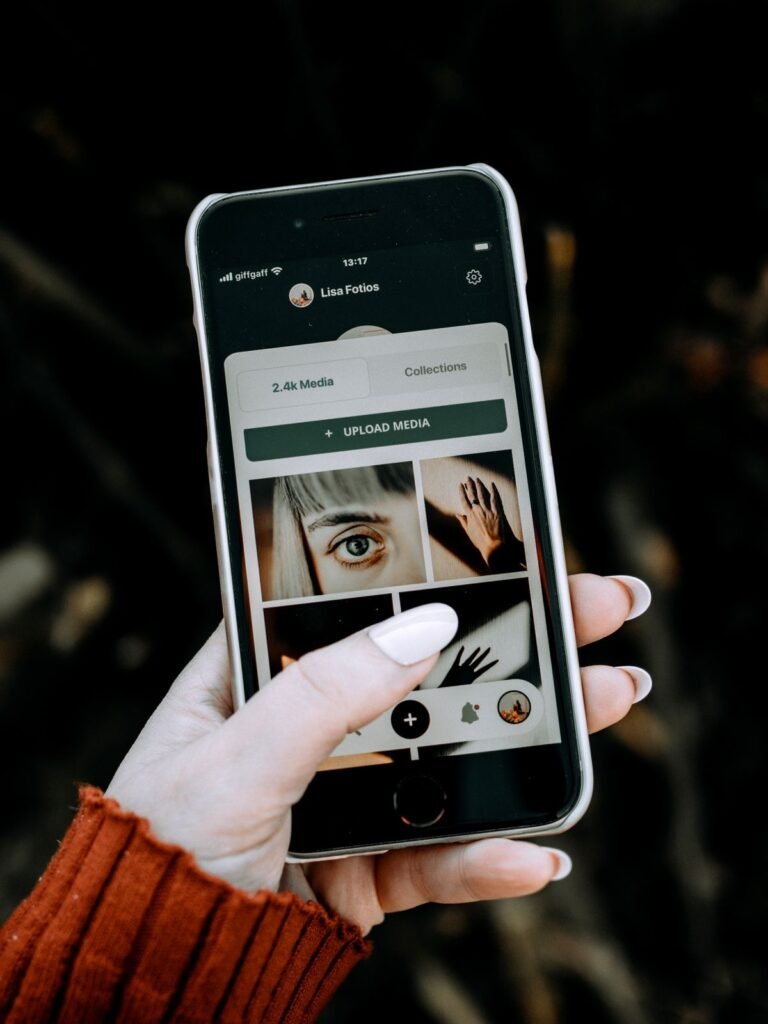 Person holding a smartphone with photos on the screen