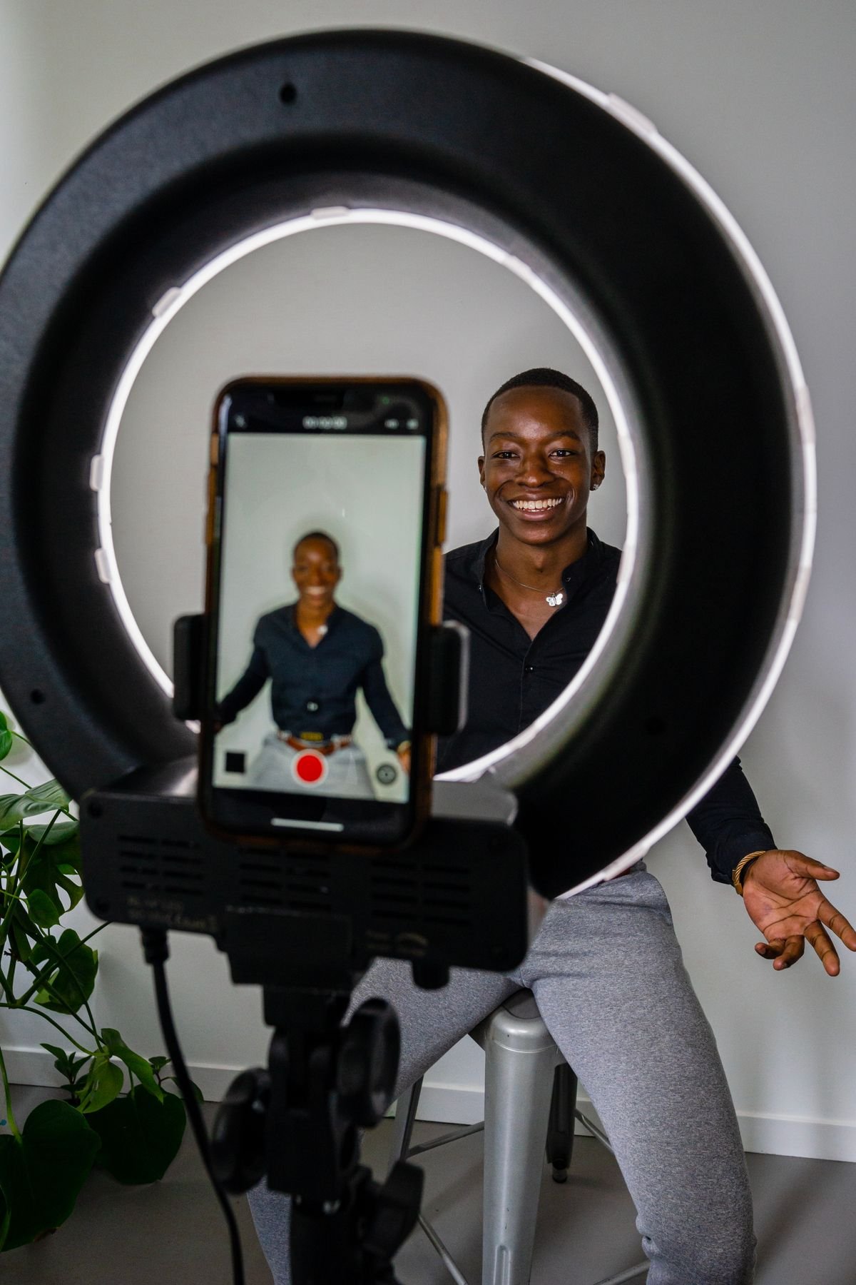 Man sitting in front of a ring light, representing a live streaming and content creation setup