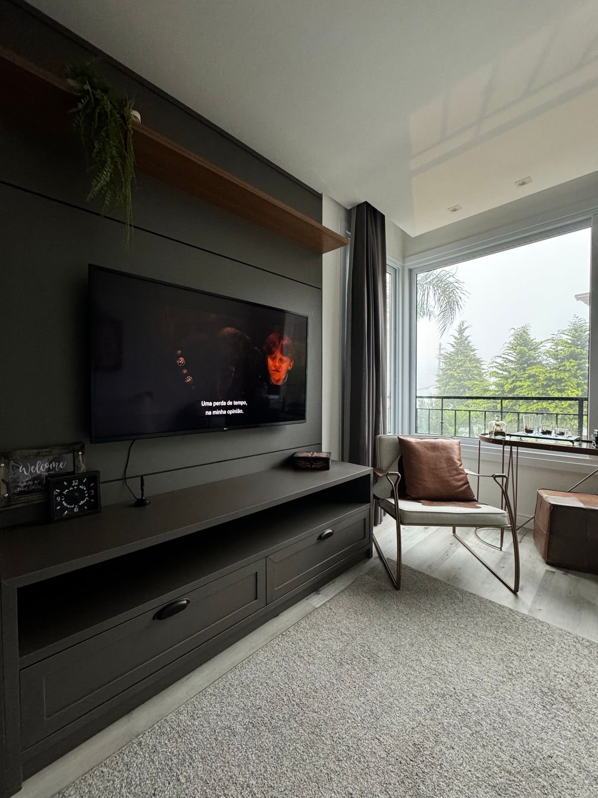 Modern apartment living room with a wall-mounted smart TV playing a movie