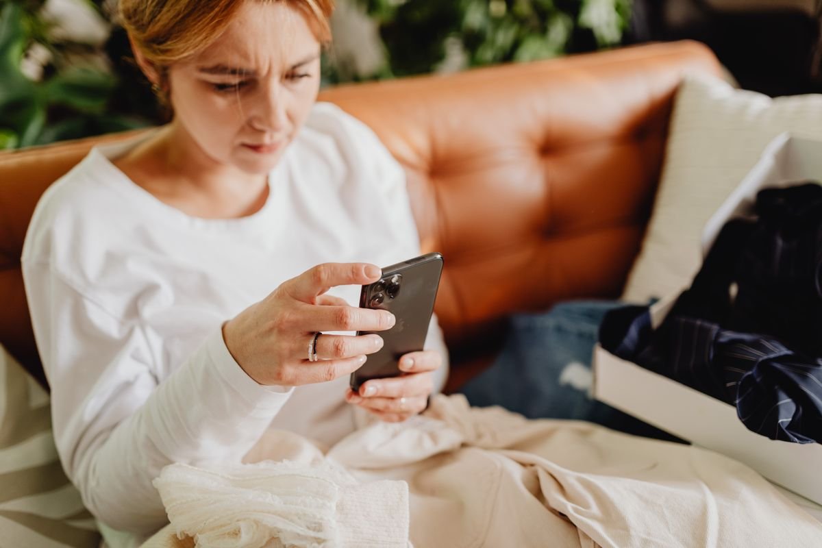 Woman relaxing on a couch while casually browsing content on her phone