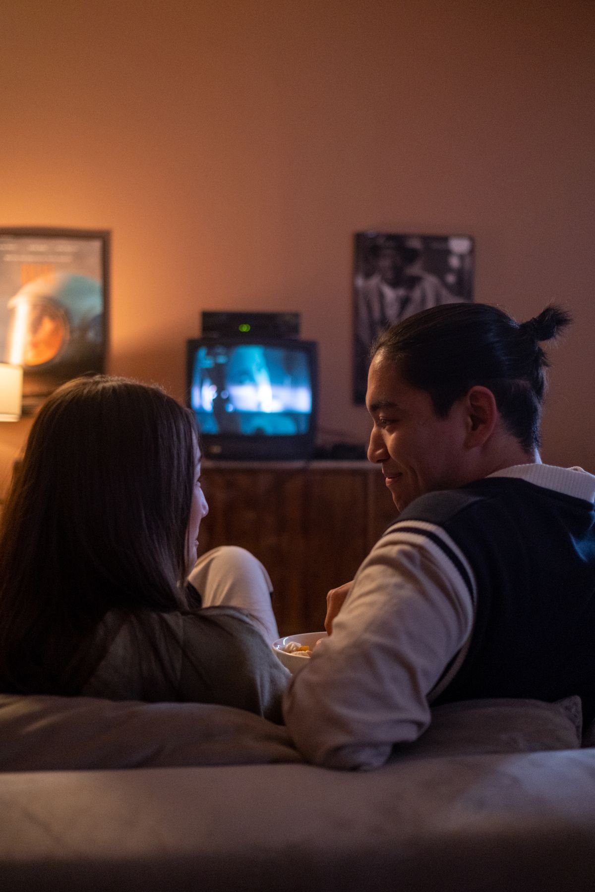 Couple watching an old movie together with popcorn, retro-style room