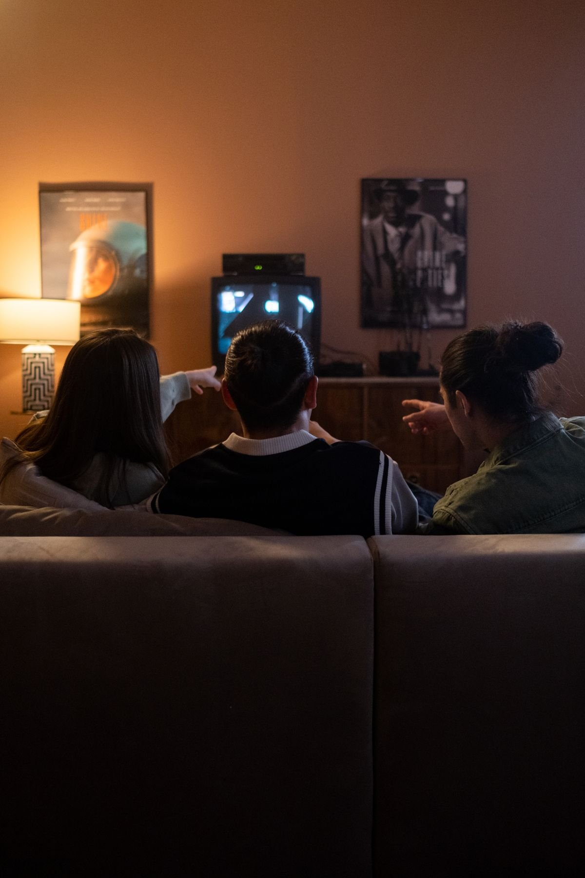 Friends sitting together on a couch casually watching TV